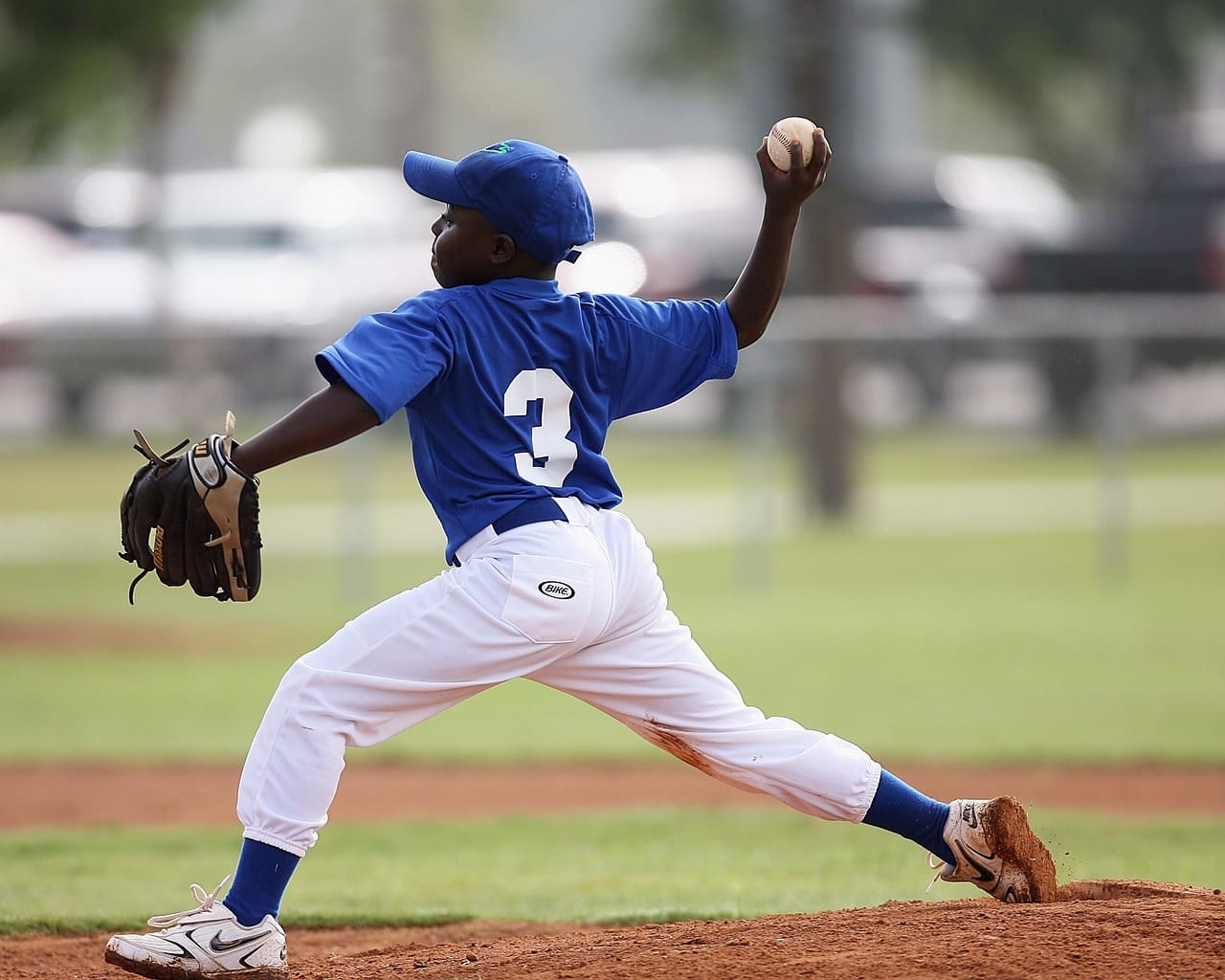 A baseball player in the middle of throwing a ball.